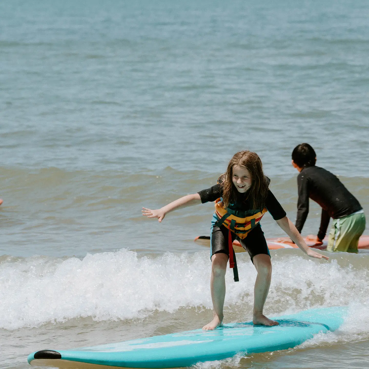 kid learning how to surf at summer beach camp
